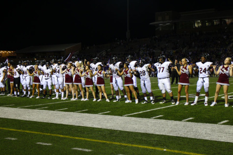 Cheerleaders and football players cerebrating their win with the school song