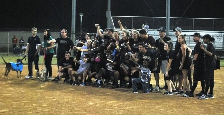 All the students and teachers that participated in the Softball game lining up for a post-game photo, some dogs from a local shelter joining them.