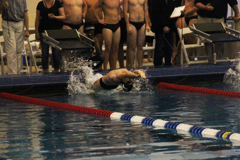 Junior swimmer Jacob Gamble lunges backward at the beginning of the race