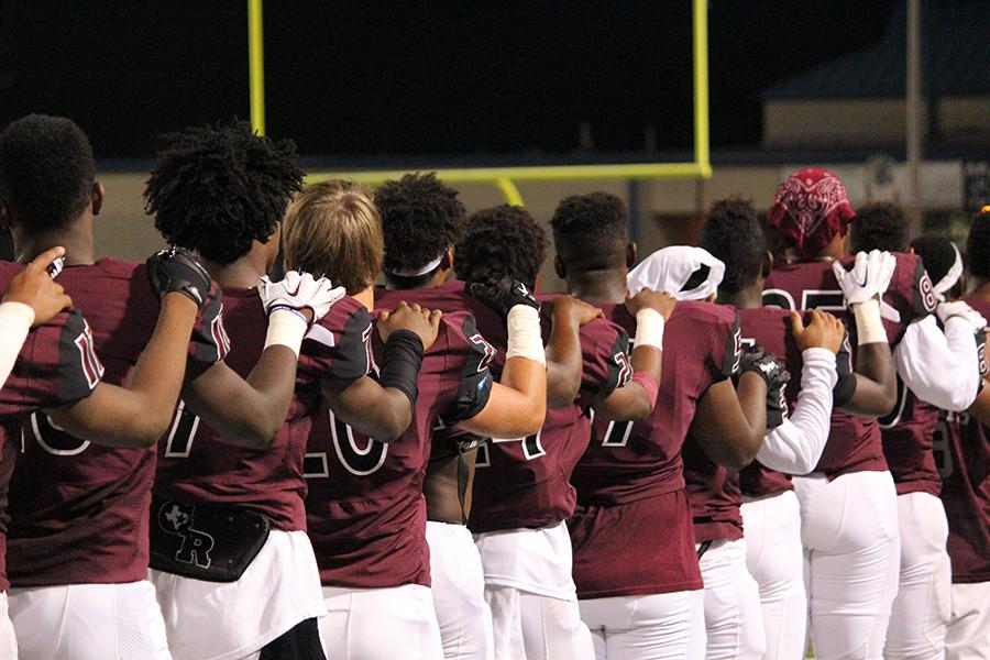 Football players line up for the alma mater 