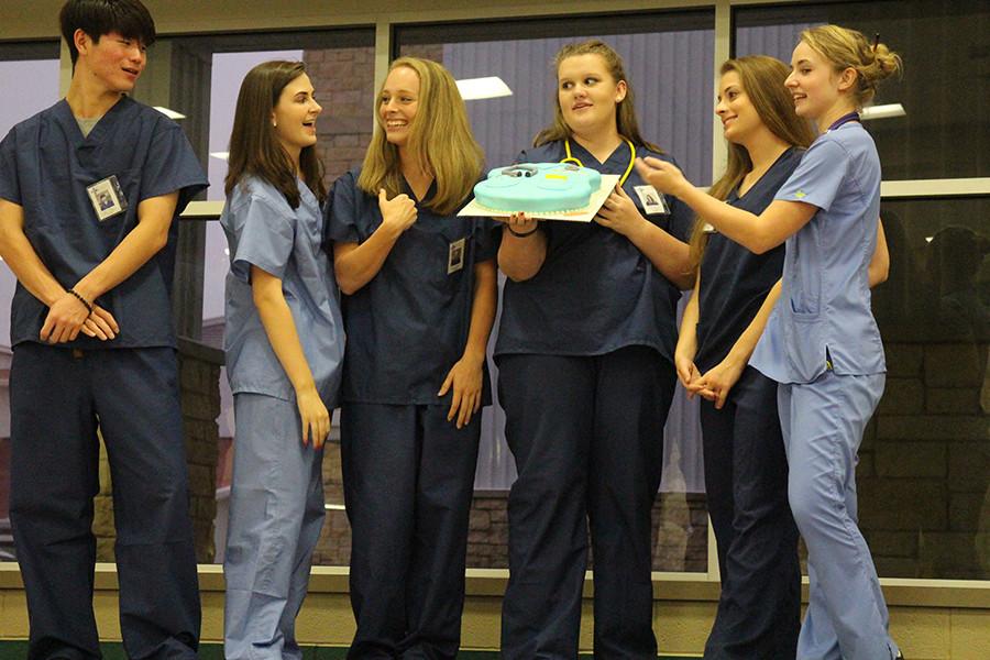 (From Left to Right): Brian Noh, Grace Elliott, Sydney Scott, Kate Anderson, Sarah DeNeefe and Lyndsay Millican dressed as Greys Anatomy cast and presenting their cake. 