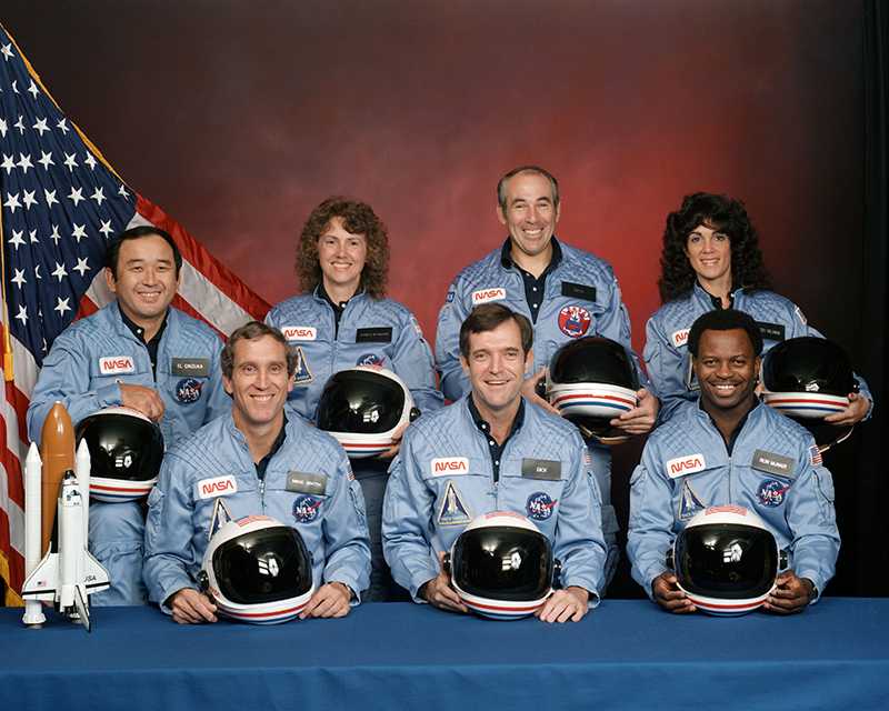 The Challenger Crew.  In the back row from left to right: Ellison S. Onizuka, Sharon Christa McAuliffe, Greg Jarvis, and Judy Resnik. In the front row from left to right: Michael J. Smith, Dick Scobee, and Ron McNair.