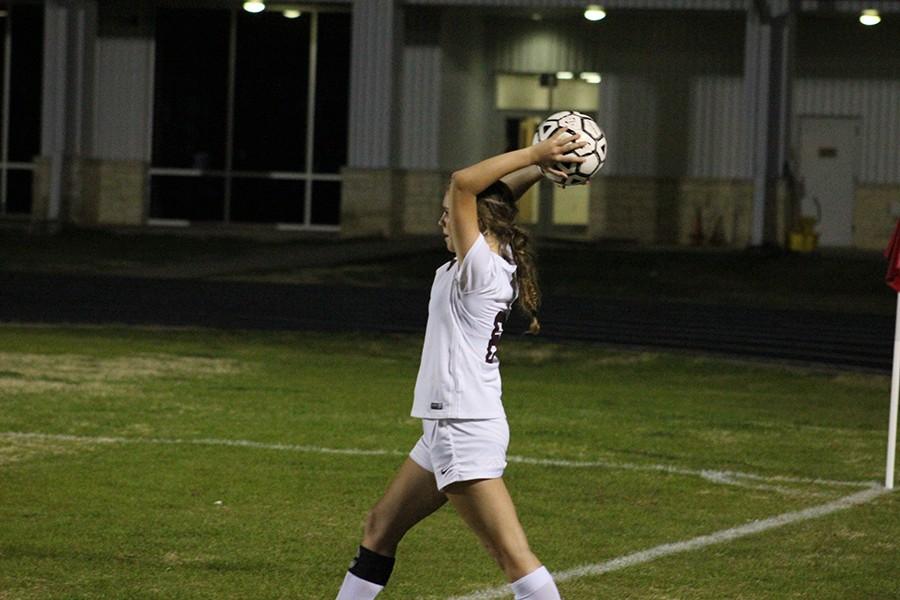 Senior Mehgan Burger winds back to launch the ball onto the field