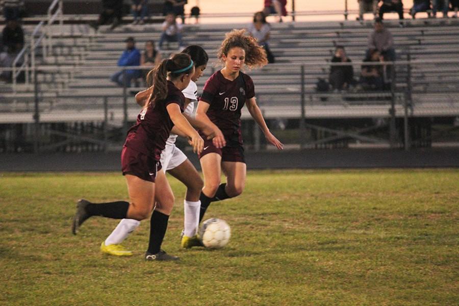 Two JV defenders close in on the opposing teams player