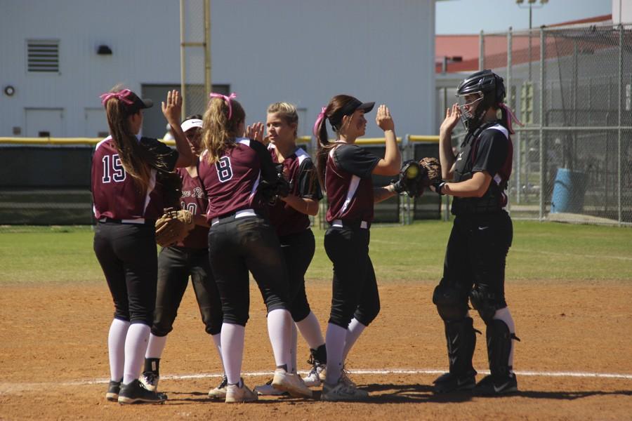 The team huddles to encourage each other before the inning begins. 