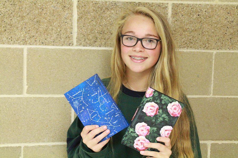 Heather Wunsch displays two of the three designs she paints for journals. 