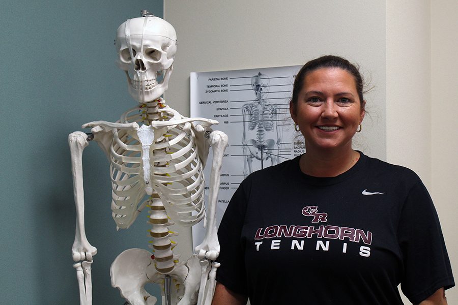 Ms. Raley standing next to Bob the skeleton. 