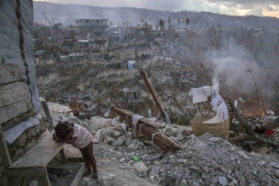 On 10 October 2016 in Jérémie, Haiti, a toddler rests near collapsed homes on top of a hill.  One week after Hurricane Matthew, as schools re-open across the country, more than 100,000 children will be missing out on learning after their schools were either damaged or converted into shelters.

Hurricane Matthew passed over Haiti on Tuesday October 4, 2016, with heavy rains and winds. While the capital Port au Prince was mostly spared from the full strength of the class 4 hurricane, the western area of Grand Anse, however was in the direct path. The cities of Les Cayes and Jeremie received the full force sustaining wind and water damage across wide areas. Coastal towns were severely damaged as were many homes in remote mountainous regions. International relief efforts are underway to provide food water and shelter to the people affected by the storm.

An estimated 500,000 children live in the Grande Anse Department and Grand South Department in southern Haiti, the areas worst hit by Hurricane Matthew.  UNICEF had prepositioned emergency supplies with national authorities to reach up to 10,000 people.  On 8 October, six water trucks arrived in Jeremie and Les Cayes, the respective capital cities within the Departments.  Additional water and sanitation supplies, such as water purification tablets, water bladders and plastic sheeting, have been dispatched to the most affected departments in the westernmost tip of Haiti.  As of 10 October, UNICEF delivered blankets, buckets, water purifying equipment and cholera diagnostic kits.