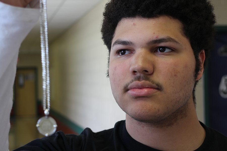 Nickolas holding a Peruvian Sol necklace.