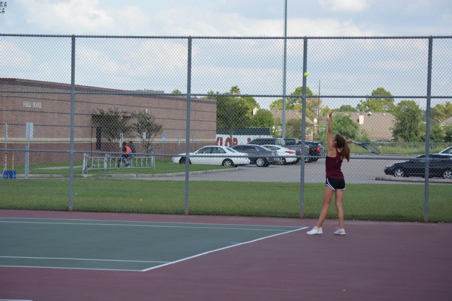 Lauren Caples tosses the ball to serve.