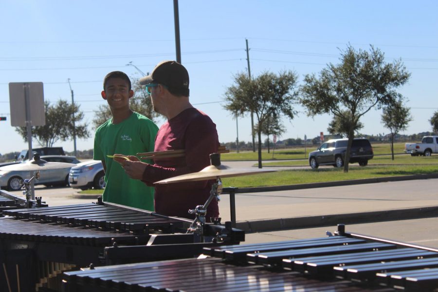 Percussion director Mr. Davis explains to Millan how to play 