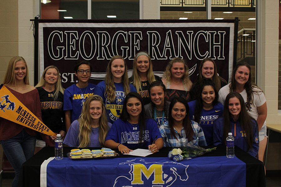 Taylor Pesina with all of her friends as she signs for her collage. 