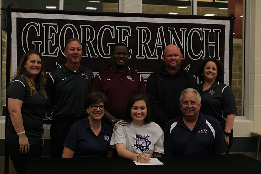 Lexie Shafer signs with her collage for volleyball. 