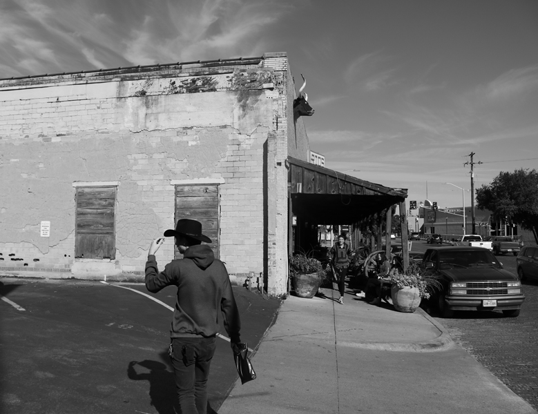 A lone cowboy tips his hat