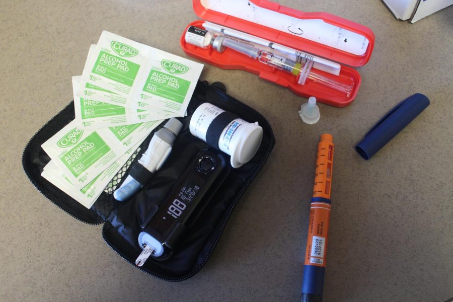 Necessities for diabetics including, an insulin pen, a blood sugar checker, and a syringe and needles.   