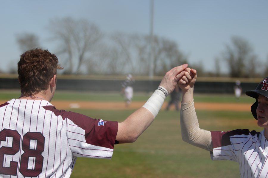 DH Joseph Menefee congratulates PR Fisher Byers after he touches home plate 