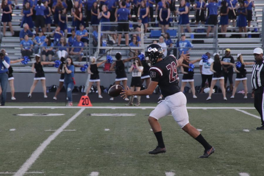 Erik Michel(12) drops the ball to punt to the other side of the field to get them deeper from the end-zone.