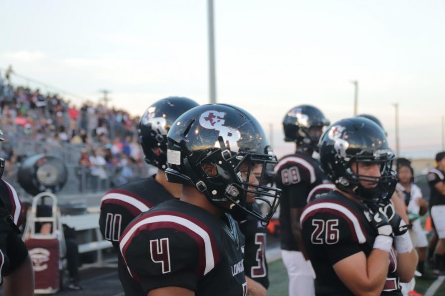 T Mcgee(12) stands on the sideline as the defense hold the field.