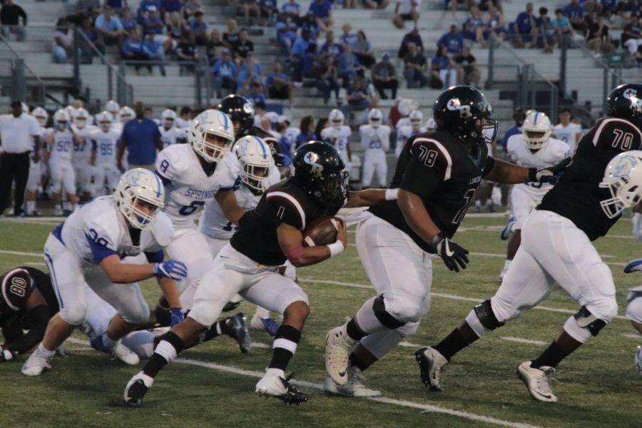 Jayren Miller(12) on the run behind his linemen looking for an open hole.