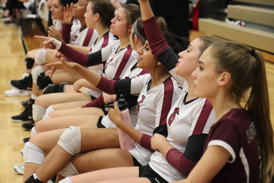 The freshman team cheering for their team mates on the court. 