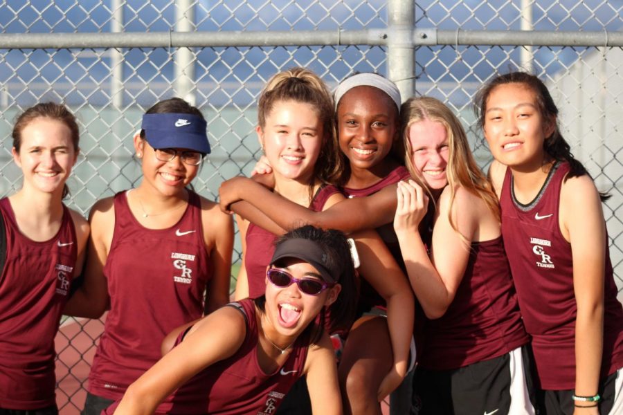 Freshman girls cheer on their tennis team.