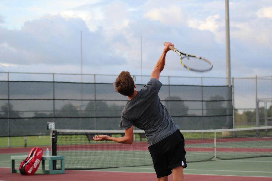 Tyler Gray (9) serving the ball.