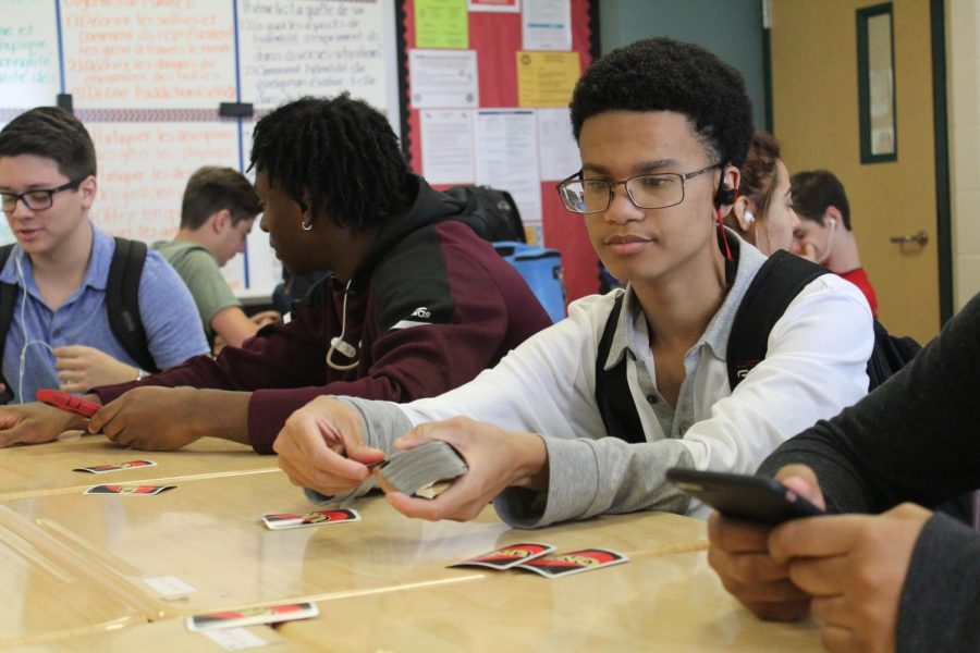 Jordan Green (12) deals UNO cards to his friends in advisory.