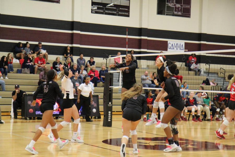 The varsity volleyball team jumping for glory.