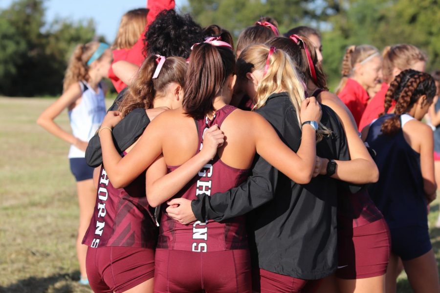 The varsity team in huddle to motivate each other and hype each other up before the race.