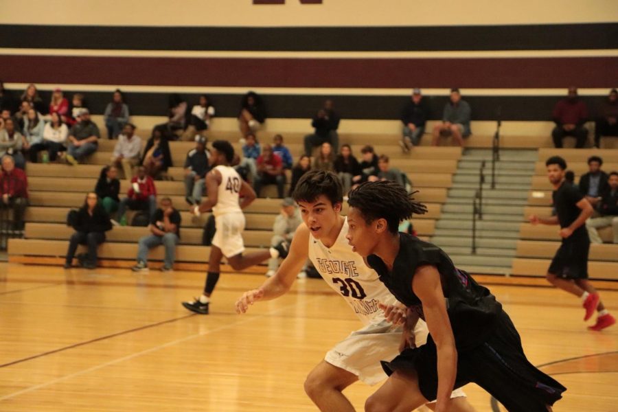 Caden Cook (11) running to defend and block the shot