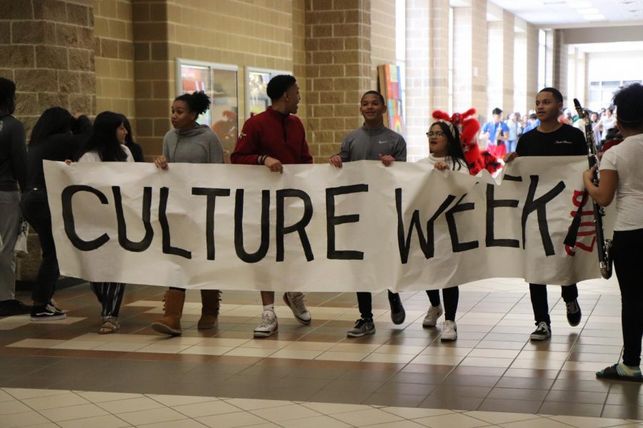 NHS members leading the Culture Parade with the Culture Week banner. 