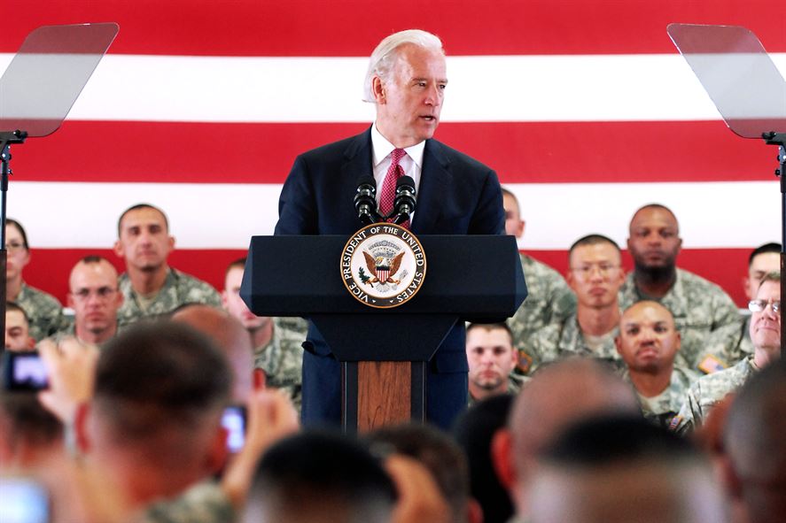 Joe Biden giving a speech about the soldiers in the background