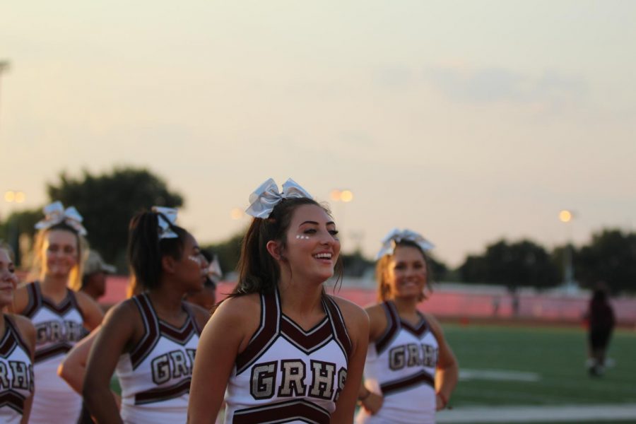 Senior captain Jenna Christoffel leading fellow cheerleaders in a sideline dance