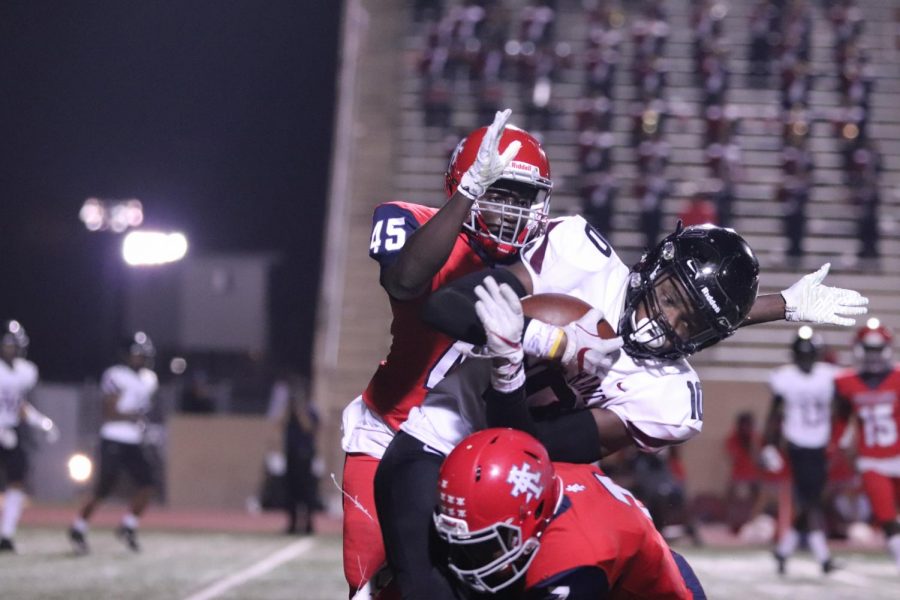 No. 10 Ben Taylor (12) catching the difficult pass thrown by No. 4 Sam Miller (11) and holding it with all his might as he gets tackled by Alief Taylor.
