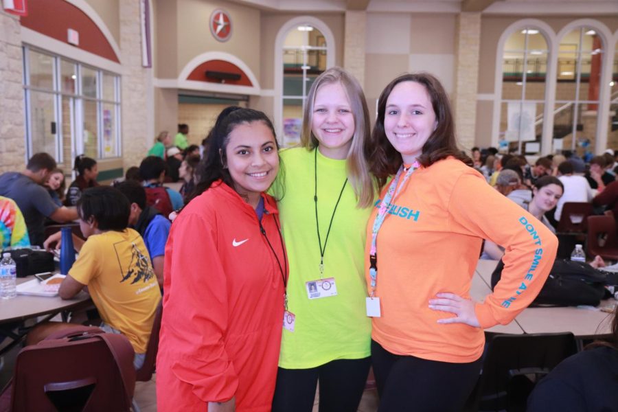 Nohemi Avalos (11), Mia Fineman (11), and Lylian Tharp (11) posing with their bright neon, highlighter like, colored shirts.