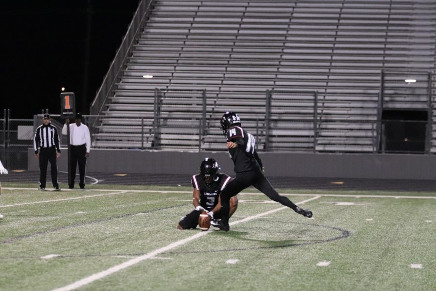 No. 14, Carlos Villagomez(12), gets ready to kick the field goal after the touch down.