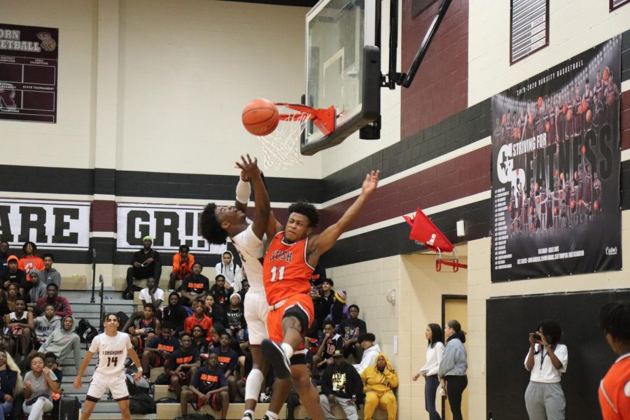 No. 3, Ori Limbrick(11), jumps above No.11 to make the basket.