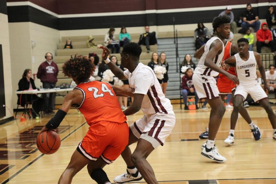 No. 5, Jordan Lewis(11), attempts to get the ball from No. 24 while dribbling down the court.