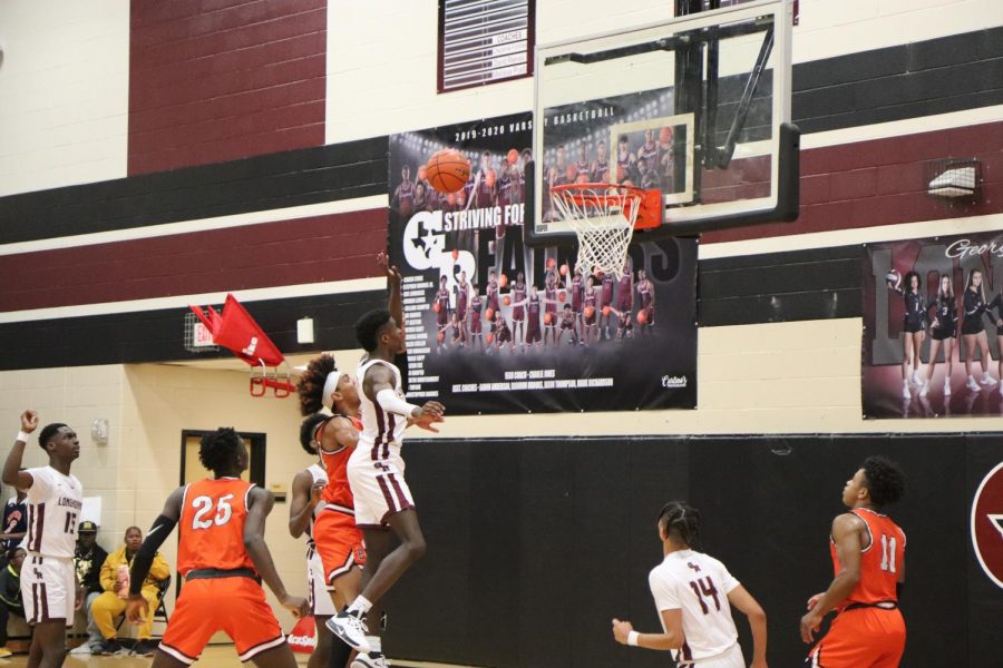 No. 5, Jordan Lewis(11), shoots the ball towards the basket, while avoiding Bush.