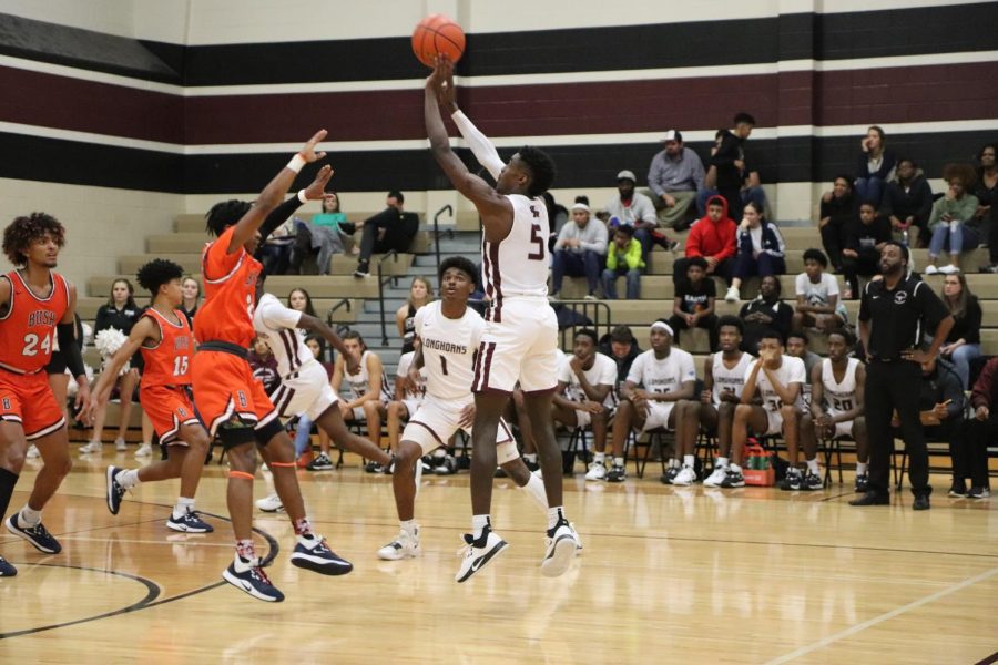 While Bush attempts to block the shot, No. 5, Jordan Lewis(11), jumps in the air and makes the basket.