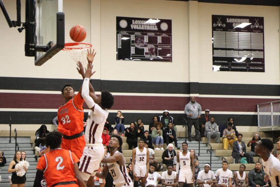 No. 3, Ori Limbrick(11) scores a basket while No. 92 tries to block his shot.