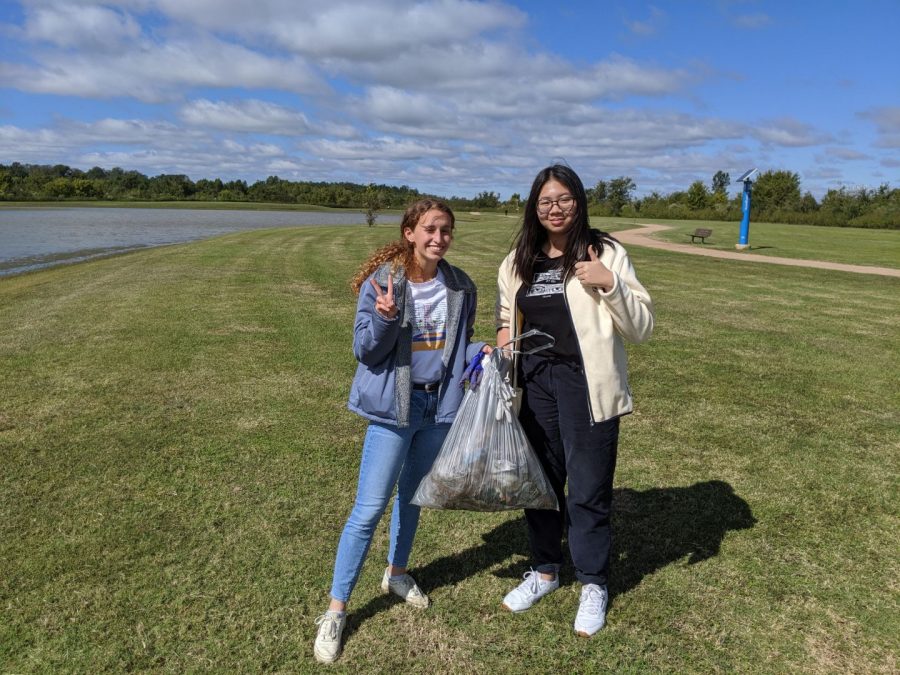 Ave Breeze(on the left) and a participate in the tree huggers club spend their saturday morning picking up trash at the sugarland park.