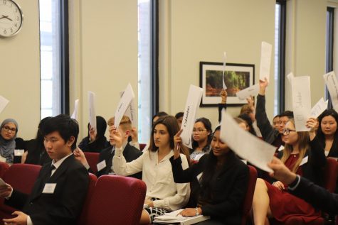 Delegates hold up their placards as they agree to a 15-minute caucus.