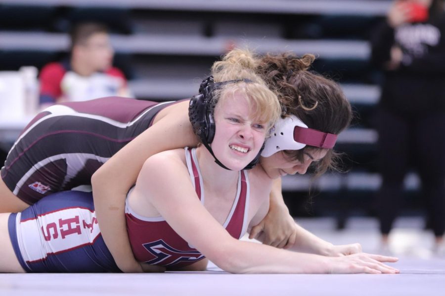 Kayley Perez (11) starting off her first round pinning Tompkins and trying to flip her over for the final pin.
