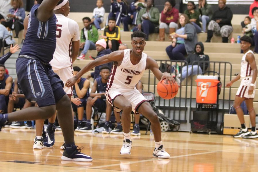 No. 5 Jordan Lewis (11) dribbling the ball with power as he inches towards attempting a 2 pointer.