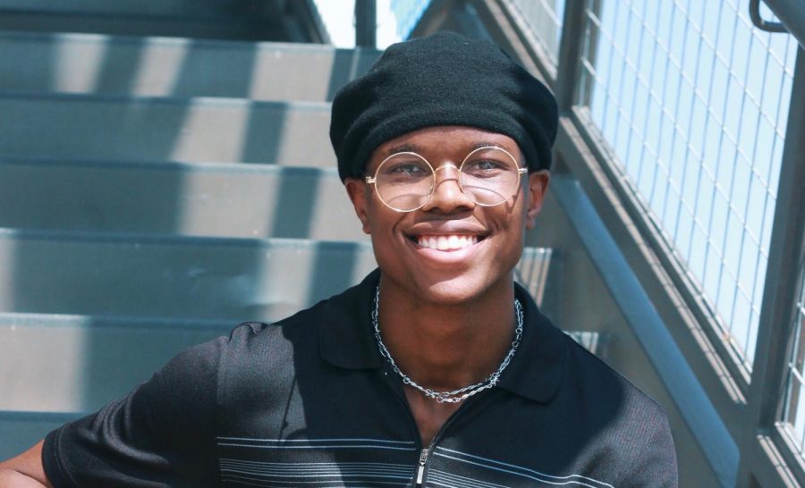 Chübby Uchenna (12) sitting on a staircase flashing a pearly white smile with grace.