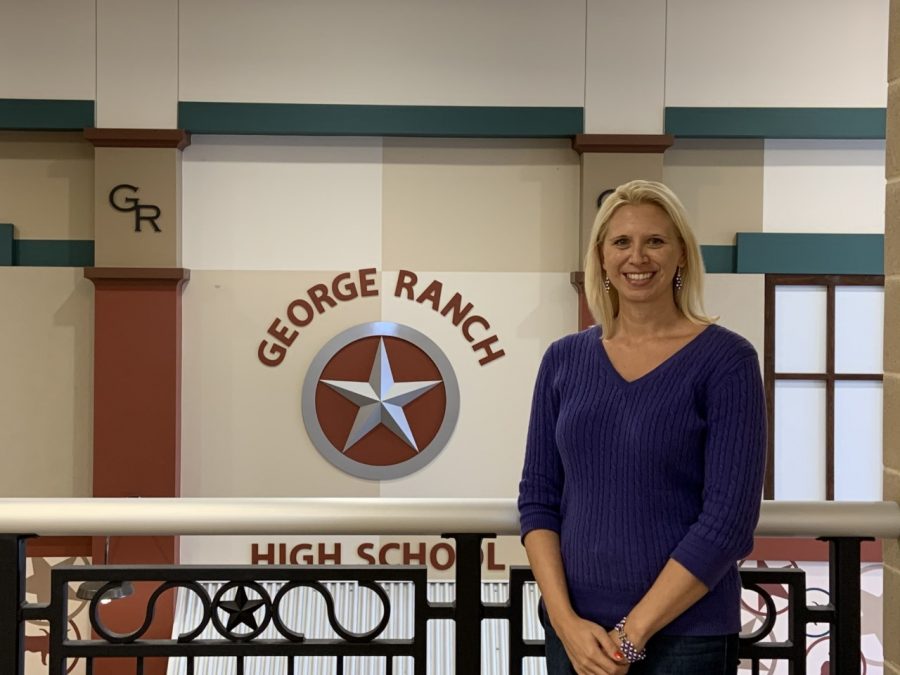 Mrs.+Hunt+proudly+standing+in+front+of+one+of+the+George+Ranch+signs.+She+strives+to+make+her+students+feel+like+they+can+be+themselves.