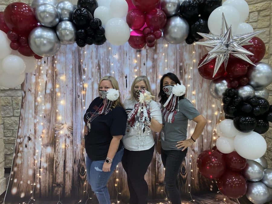 Mrs. Thomas, Mrs. Patterson, and Mrs. Moreno pictured posing in front of the pop up photo op in the main hallway. 