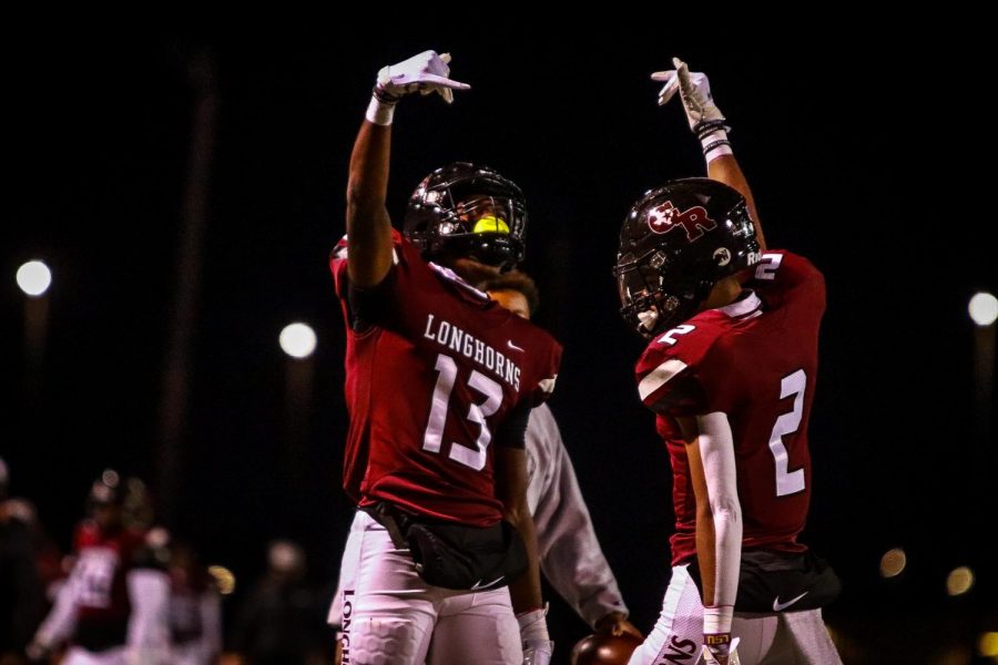 No. 13 Javon Gipson (12) and No. 2 Donovan Dixon (11) throw their Horns up in celebrant of a good play for the Longhorns.