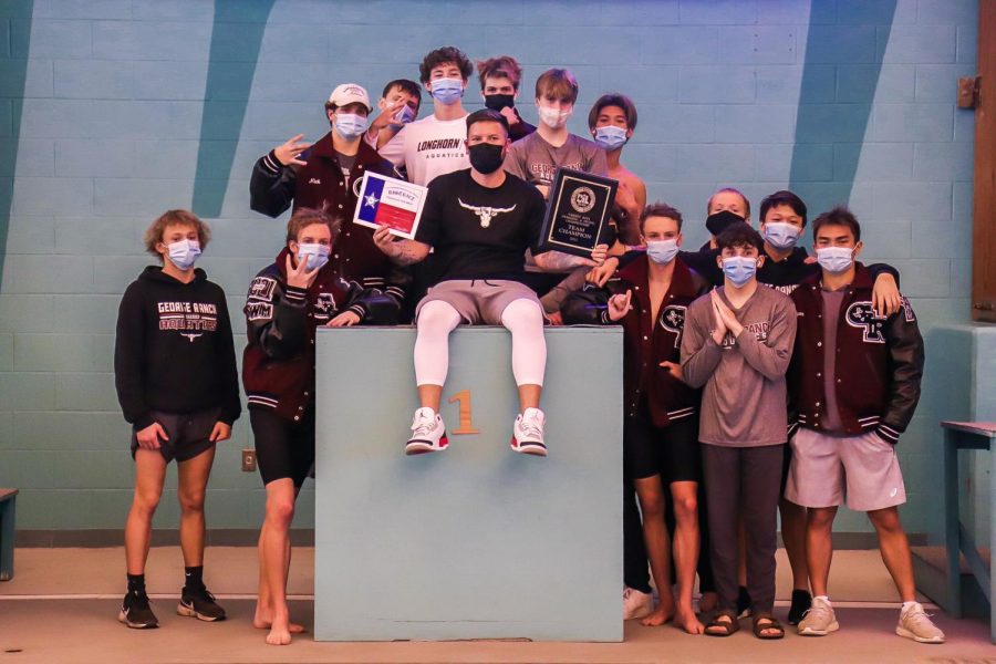 The boys' varsity swim team showcasing their "Victory Season" pose after tieing for the district title with Clements, both with a final score of 154. 
